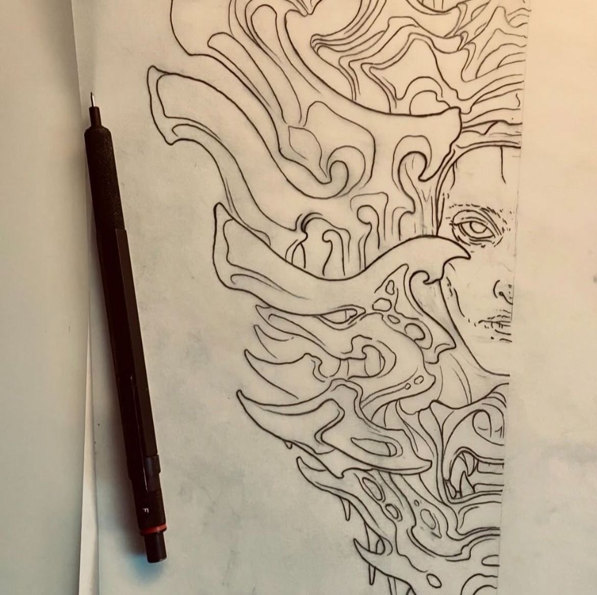 Detaljerad renritning av tatueringsmotiv med penna på papper.