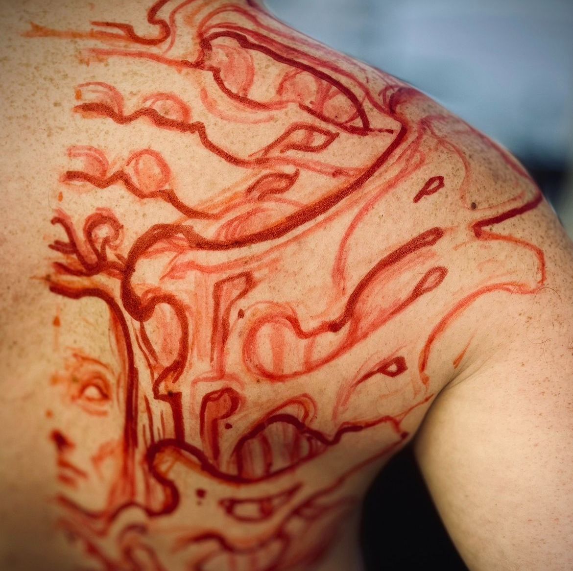 Uppritning av japanskt tatueringsmotiv direkt på axel för att anpassa form och storlek.