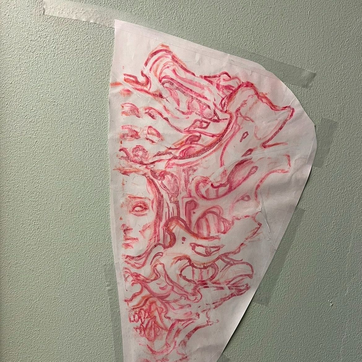 Stencil av tatueringsmotiv i rött placerad på hud inför tatuering.